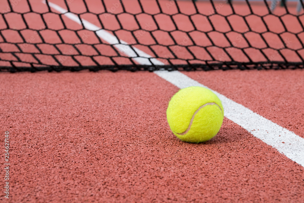 Tennis ball in hardcourt in net background