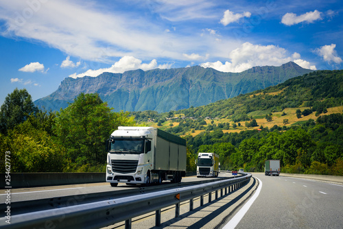 Trucks drive on the European highway on the Alpine mountains. © Rumir