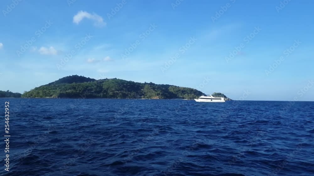 View of boat cruising at the sea. Phuket Island in the background. View of boat cruising at the sea. Phuket Island in the background.