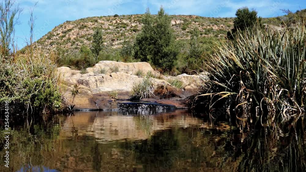 Tranquil scene of water falling into fresh water pool in mountains of remote area outside Oudtshoorn, South Africa. Tranquil scene of water falling into fresh water pool in mountains of remote area outside Oudtshoorn, South Africa.