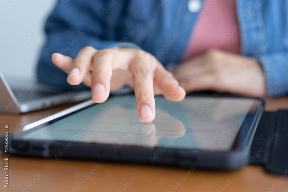 Closeup hand of asian women are using tablet on wood table Closeup hand of asian women are using tablet on wood table