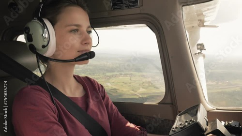 Young confident woman piloting a small civilian plane photo