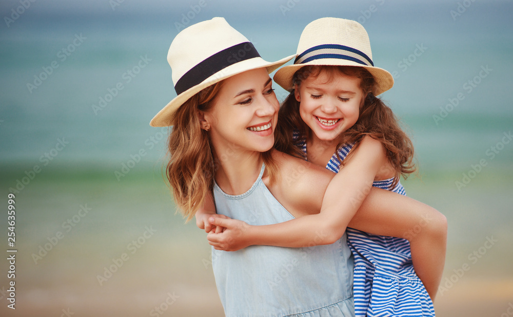 happy family at beach. mother and child daughter hug at sea.