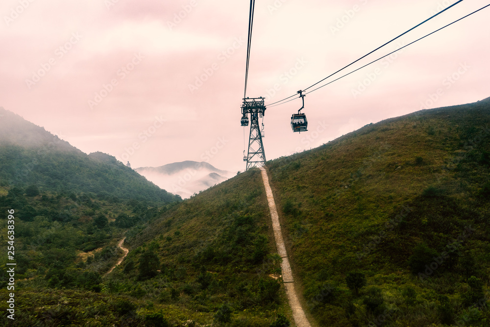 Tourist cable car in the mist to mountain peak