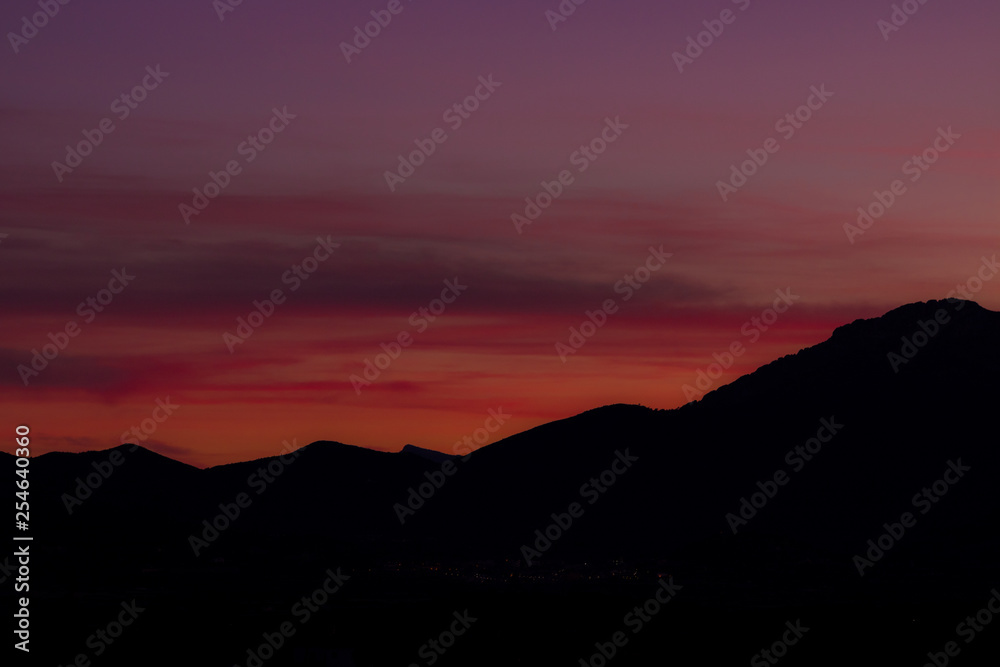 sunset sky in dark mountain silhouette 