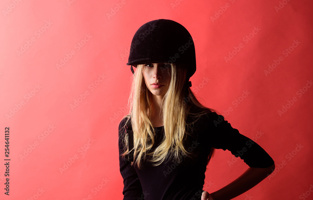 Girl jockey wear protective helmet on red background. Sport equipment concept. Safety rules. Horse riding sport. Sport accessories fashion. Woman sensual blonde wear clothes for horse riding sport Girl jockey wear protective helmet on red background. Sport equipment concept. Safety rules. Horse riding sport. Sport accessories fashion. Woman sensual blonde wear clothes for horse riding sport