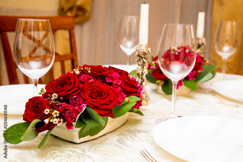 2 floral arrangements of red roses and carnations for table decoration (wedding, restaurant) on a server table, table setting 2 floral arrangements of red roses and carnations for table decoration (wedding, restaurant) on a server table, table setting