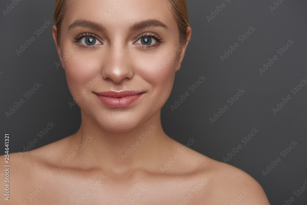Portrait of smiling young lady on the grey background Portrait of smiling young lady on the grey background