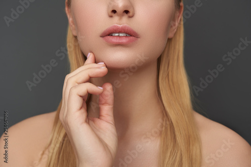 Close up of woman with bare shoulders touching her cheek
