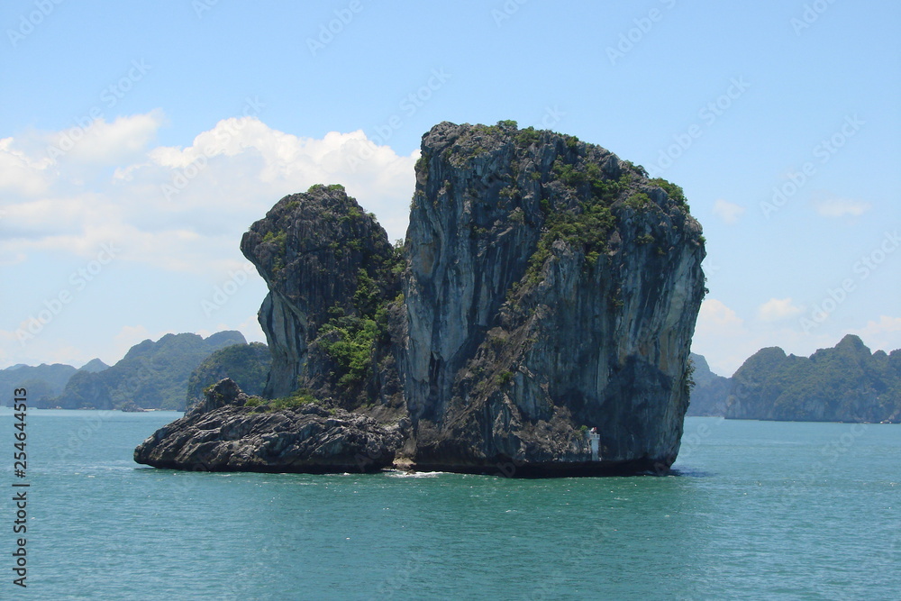 Panorama from the ship of islands of the underwater rocks covered with tropical vegetation under the rays of the midday sun.
