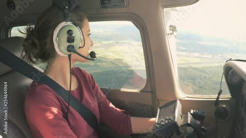 Gorgeous model piloting a small private plane looking around and smiling
