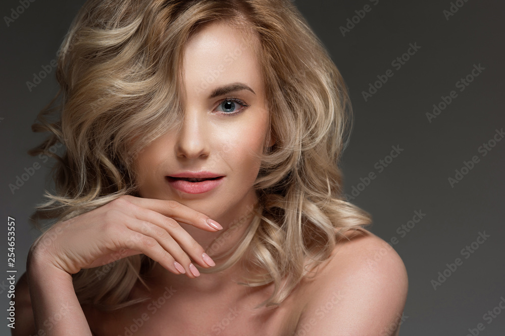 Image of woman with curly hair, with bare shoulders.