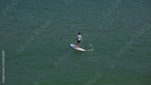Joven haciendo paddle surf en el mar