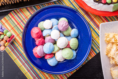 Piccoli biscottini rotondi glassati colorati su un piatto in ceramica