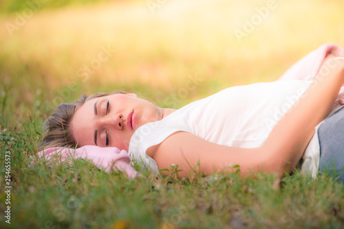 Portrait image of Young women sleeping on the grass in the park at sunset. Concept romantic and love. Warm tone.