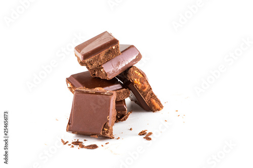 broken chocolate and hazelnuts on isolated white background.