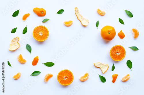 Frame of fresh orange citrus fruit with green leaves on white