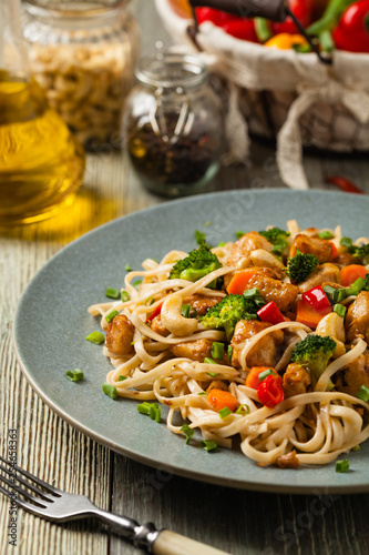 stir-fry pasta with chicken, broccoli and carrots.