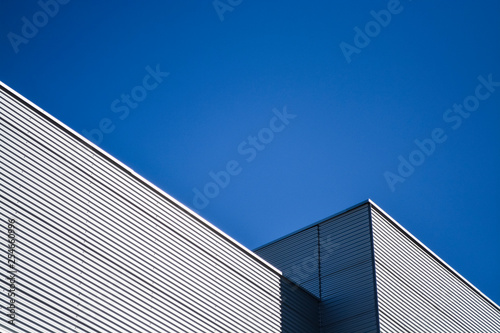 Against the background of the summer blue sky of a detail of black and gray modern constructions. Unusual architecture. Innovation