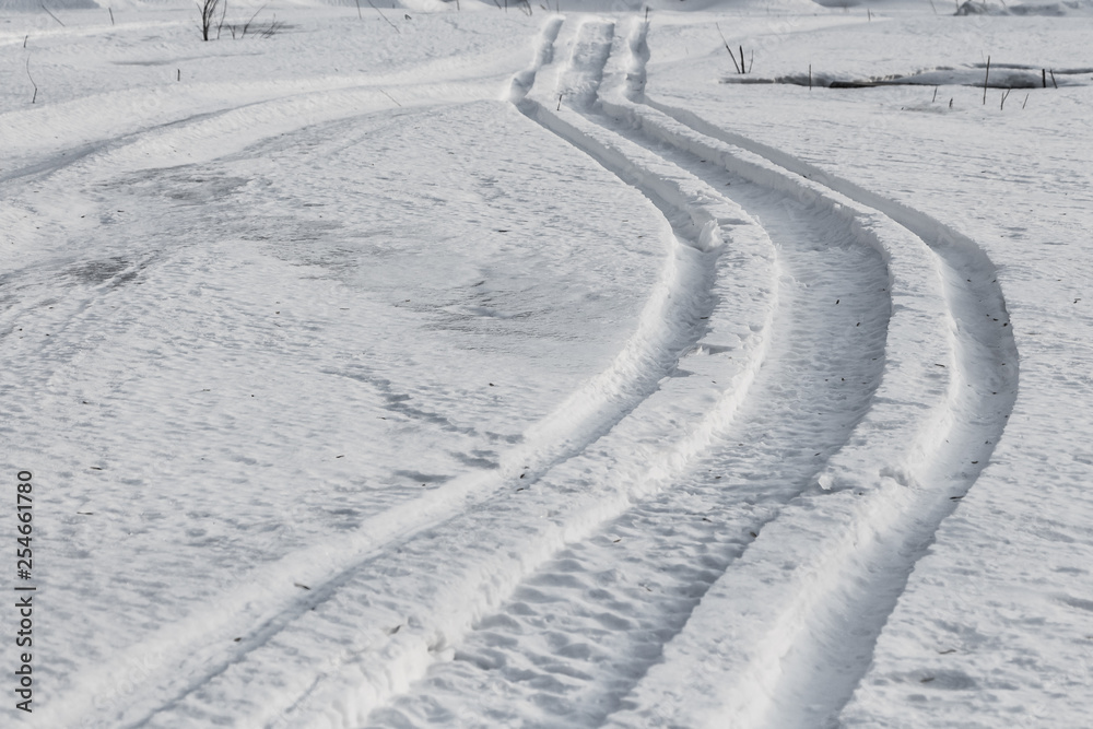 Winding snow scooter trail through winter landscape