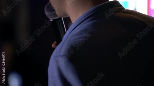 presenter with microphone and folder performs on stage