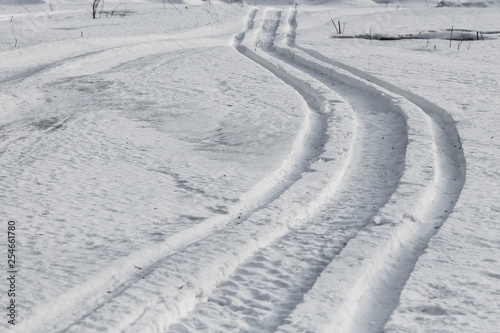 Winding snow scooter trail through winter landscape