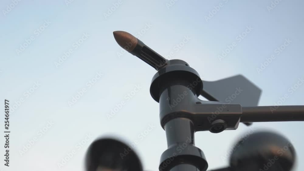 Weather vane wind gauge for direct and strength. sunset color in background., Zoom out.