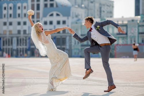 bride and groom in wedding attire dancing fiery dance in the town square