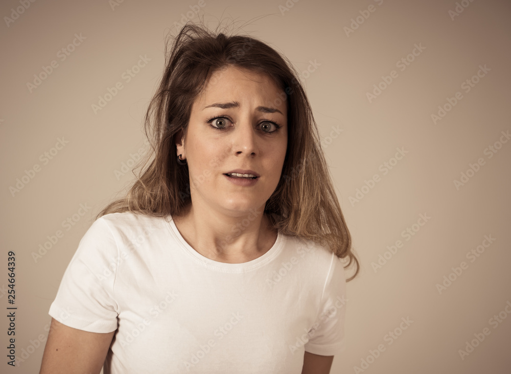 Portrait of a young attractive woman looking scared and shocked.Human expressions and emotions.