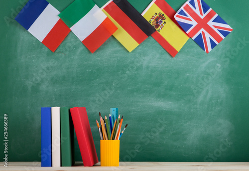 backpack, flags of Spain, France, Great Britain and other countries, books and school supplies of the blackboard