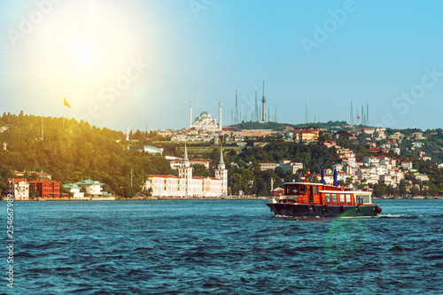 Cruise boat sails along Bosphorus passing famous Camlica Mosque, Istanbul, Turkey
