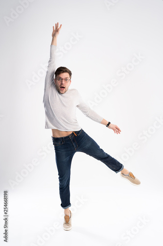 Full-length photo of funny man 30s in casual t-shirt and jeans jumping isolated over white background.