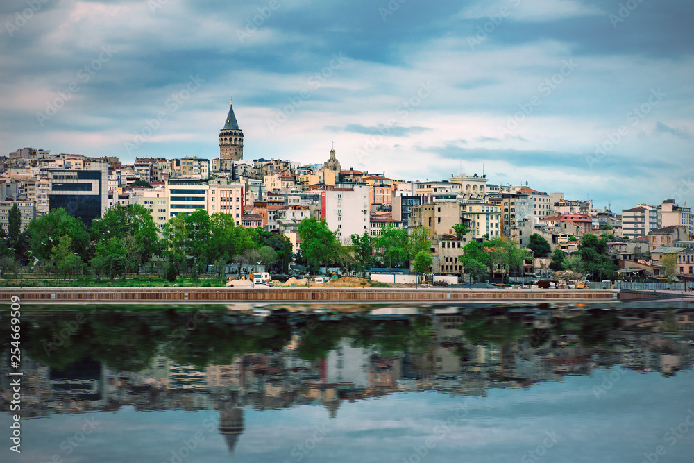 View of the coast of Istanbul with the Galata Tower reflecting in water, Turkey