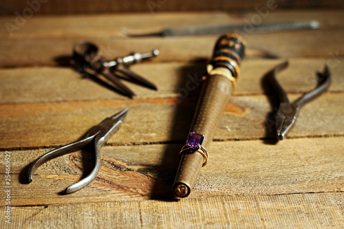 Jeweler's ring and tools on wood