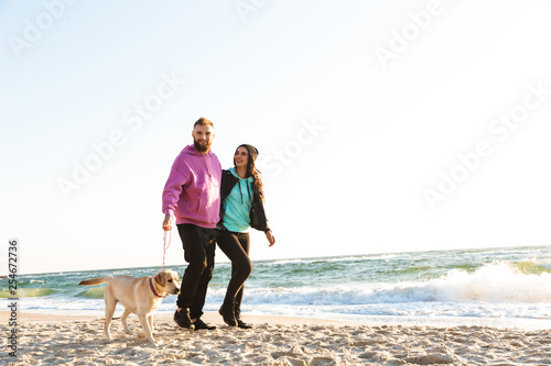 Attractive young couple walking at the beach