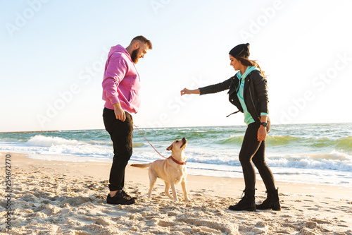 Lovely young couple playing with their dog
