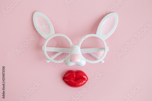Flat lay of rabbit eyeglasses with plastic lips easter abstract.