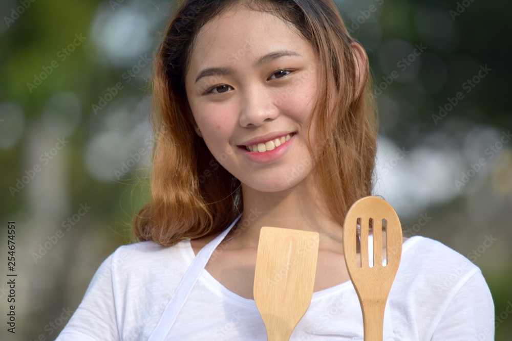 Smiling Beautiful Diverse Female Cook With Kitchen Utensils Smiling Beautiful Diverse Female Cook With Kitchen Utensils
