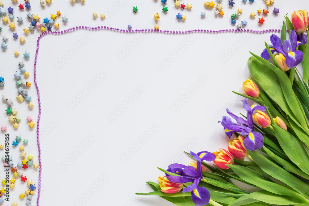 Fototapeta premium Frame made of flowers and stars on a white background