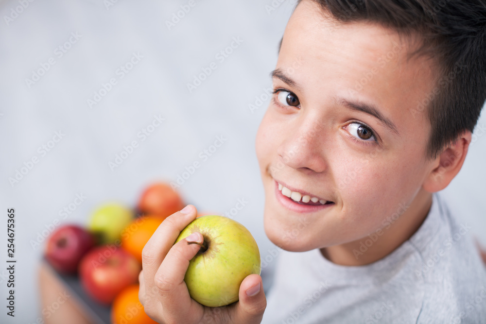 Young teenager boy holding an apple - looking up Young teenager boy holding an apple - looking up