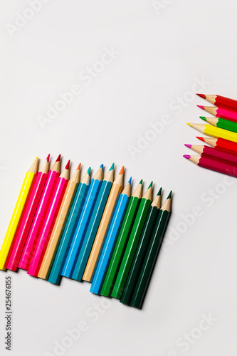Multi-colored pencils for drawing on a white table. Ready photo background.
