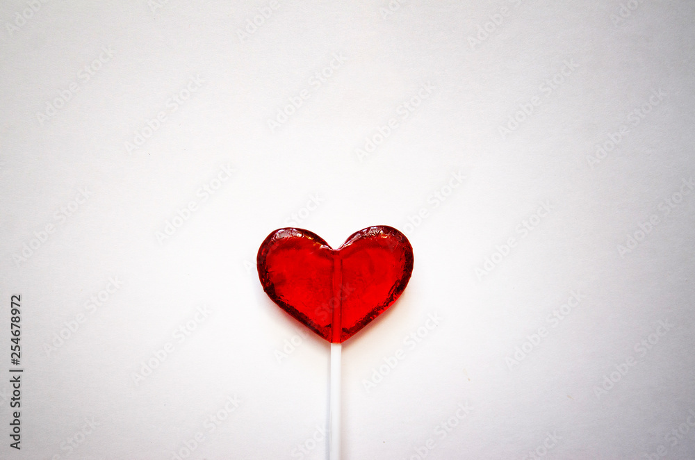 red heart shaped Lollipop on light background