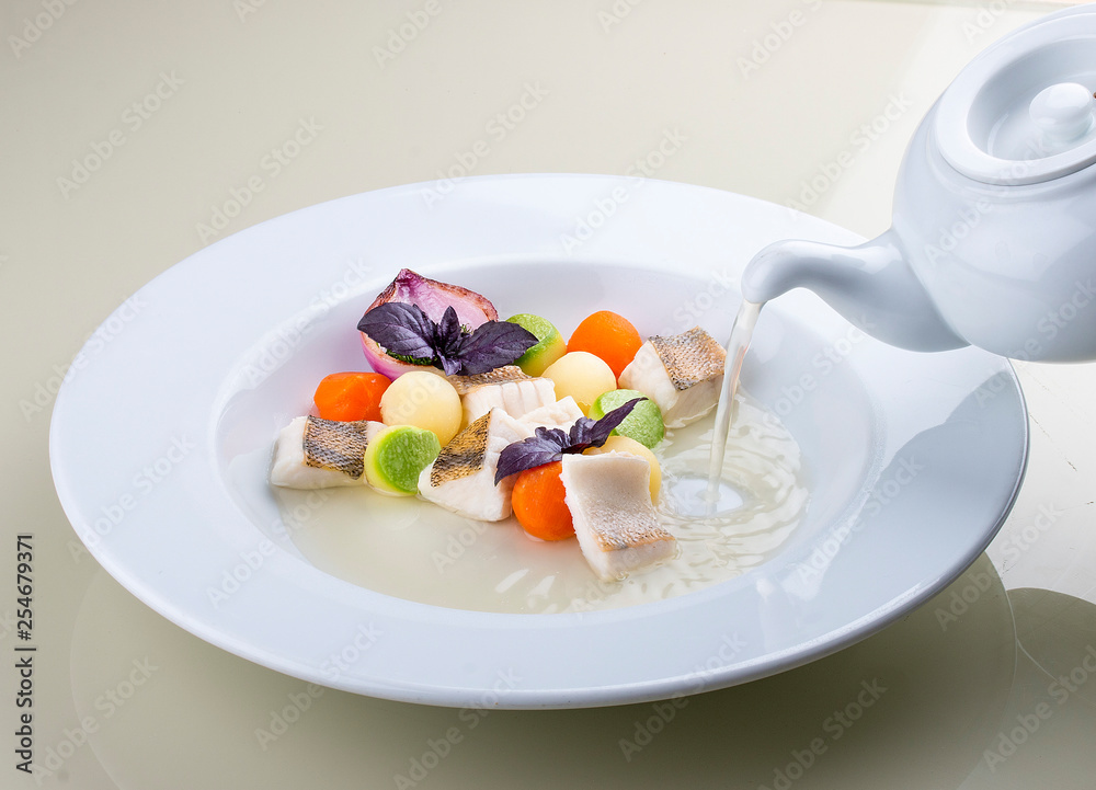 Fish soup with vegetables in the original serving