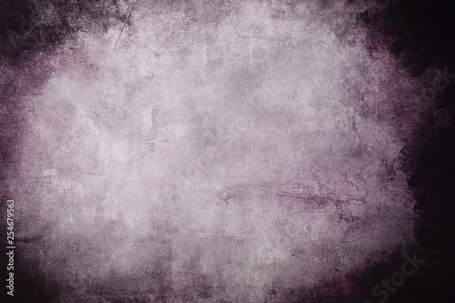 Old purple wall grungy background or texture with dark vignette borders