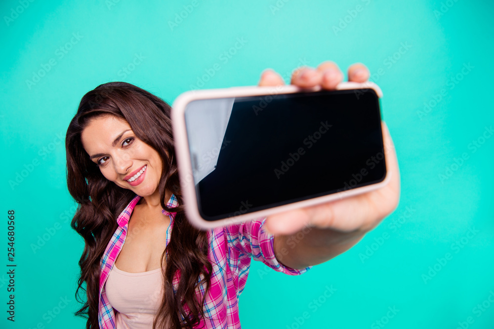 Close up photo beautiful she her lady hold look smart phone make take selfies new modern telephone wearing casual plaid checkered pink shirt outfit isolated teal bright vivid background