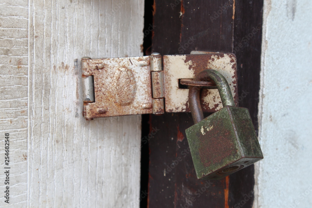 Old padlock on wooden door for security. Old padlock on wooden door for security.