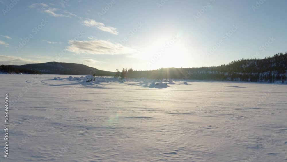 Drone flies at sunset over the beautiful ice landscape of the frozen Lake Inari in Finland, Sellaniemi, Mahlatti, Veskoniemi Drone flies at sunset over the beautiful ice landscape of the frozen Lake Inari in Finland, Sellaniemi, Mahlatti, Veskoniemi