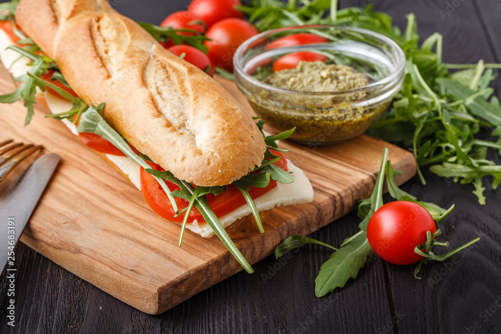 Close up of freshly made sandwich on wooden cutting board Close up of freshly made sandwich on wooden cutting board