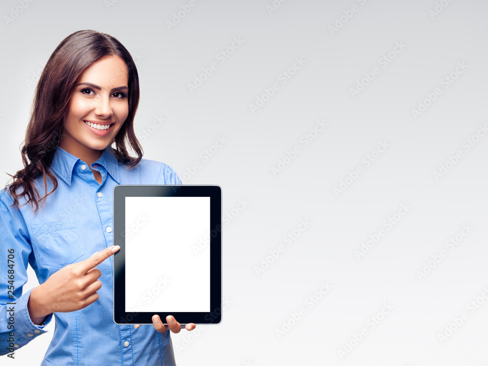 Businesswoman showing blank tablet pc, on grey Businesswoman showing blank tablet pc, on grey