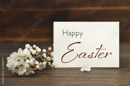 Happy Easter card. Easter card and flowering branch on wooden background